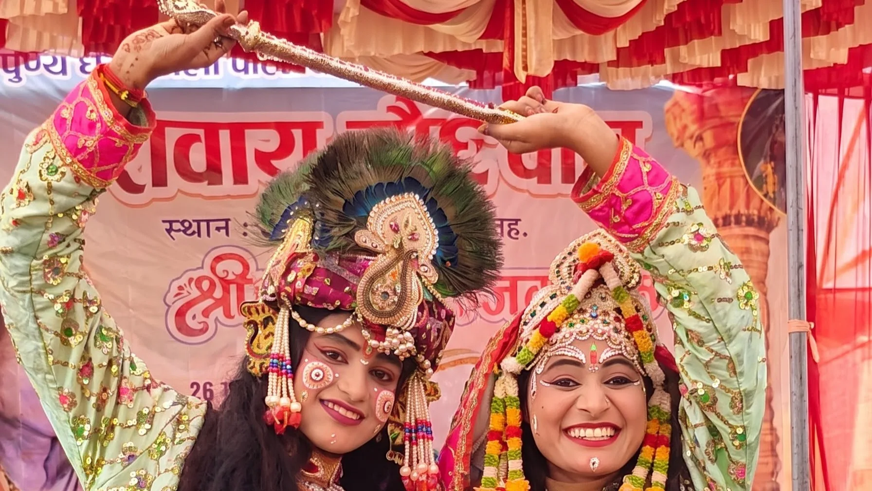 Two performers dressed as Radha and Krishna on the festival stage