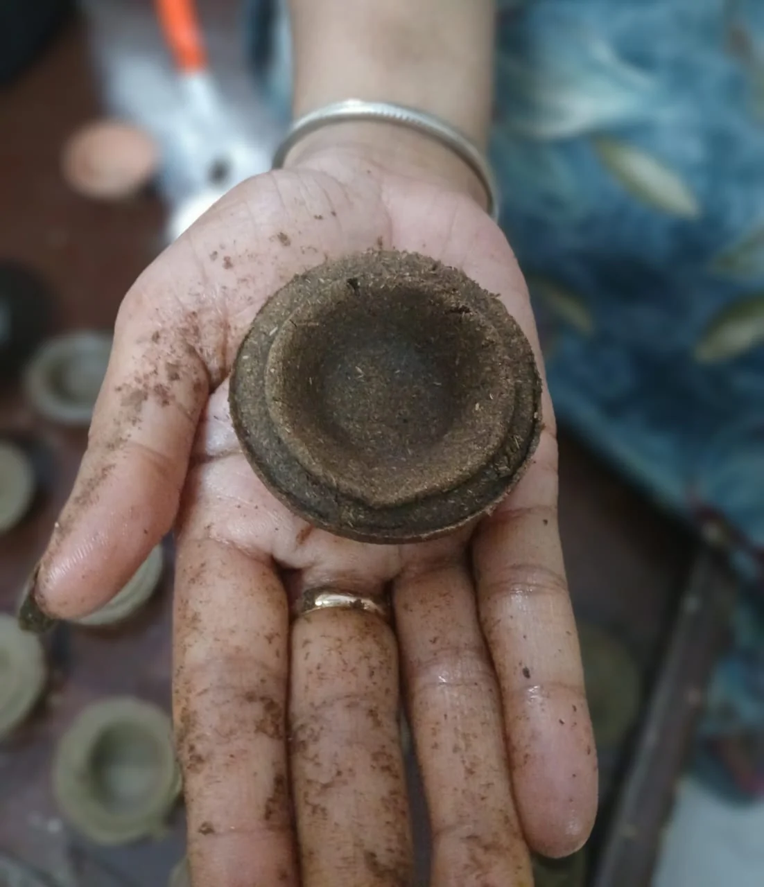 A cow-dung diya held in hand